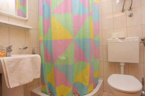 Double Room Tucepi 5263c في توسيبي: ستارة دش ملونة في حمام مع مرحاض