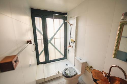 a bathroom with a window and a toilet and a sink at AYCA La Flora Hotel Boutique in Valparaíso