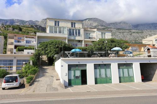 a building with a car parked in front of it at Apartments and rooms with parking space Tucepi, Makarska - 5263 in Tučepi