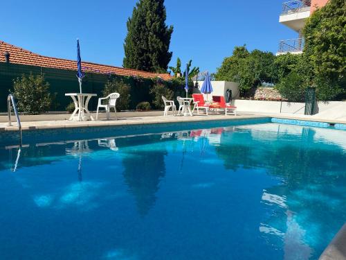 a large swimming pool with chairs and a table at Mansfield vue carte Postale Terrasse Piscine 2 in Menton