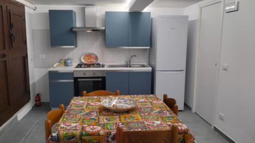 a kitchen with a table and a kitchen with blue cabinets at Mandorlo Barocco in Noto