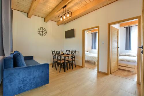 a living room with a blue couch and a table at Brzozowa Osada in Polańczyk