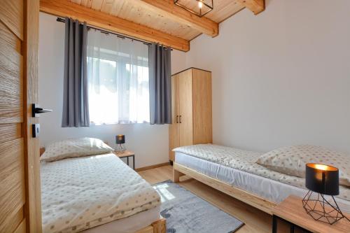 1 dormitorio con 2 camas y ventana en Brzozowa Osada en Polańczyk
