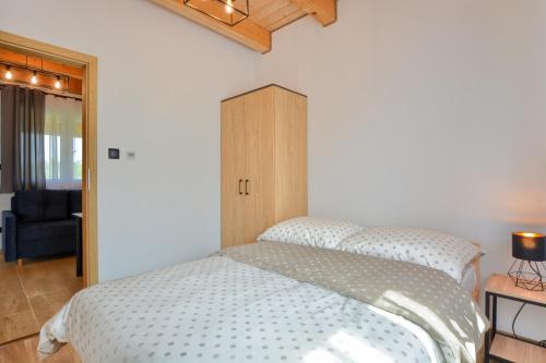 a bedroom with a bed and a wooden cabinet at Brzozowa Osada in Polańczyk