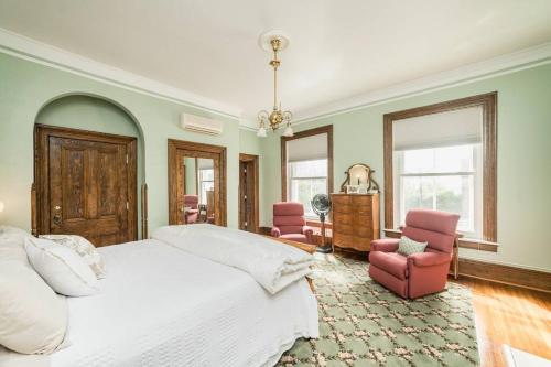 1 dormitorio con 1 cama blanca grande y 2 sillas rosas en Peaceful Easy Feelings - King Sized Bed - Sleeps 2, en Lynchburg