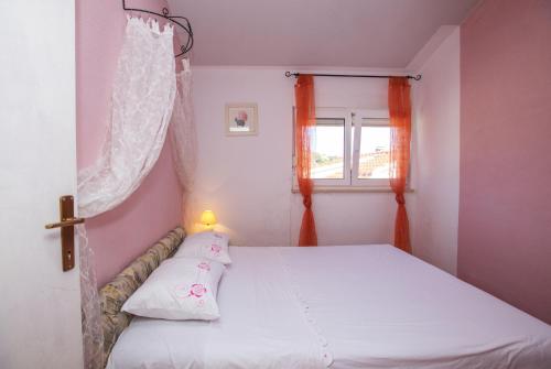 - une chambre avec un lit blanc et une fenêtre dans l'établissement Apartments by the sea Cove Kalebova Luka, Rogoznica - 13804, à Rogoznica