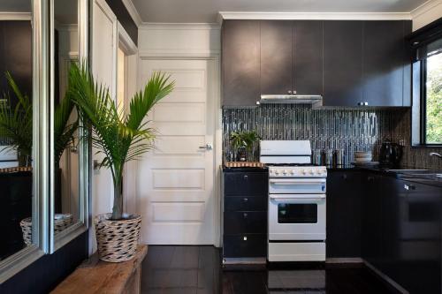a kitchen with black cabinets and a white stove at Lardi Lane- romantic getaway in Daylesford