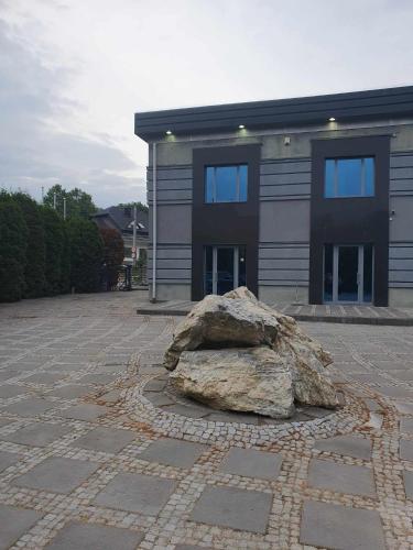 a large rock sitting in front of a building at Pokoje ze wspólną łazienką i kuchnią w centrum Starachowic in Starachowice