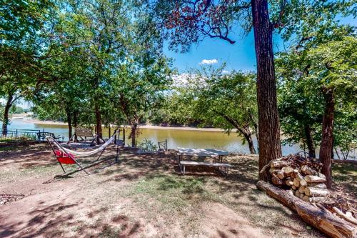 a hammock and a bench next to a lake at Brazos de Dios in Glen Rose