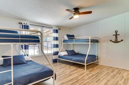 a room with two bunk beds and a ceiling fan at Lakefront Summerton Getaway with Boat Dock and Pool! in Summerton