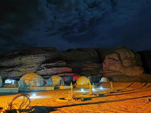 Un groupe de dômes dans le désert la nuit dans l'établissement orbit camp 2, à Wadi Rum