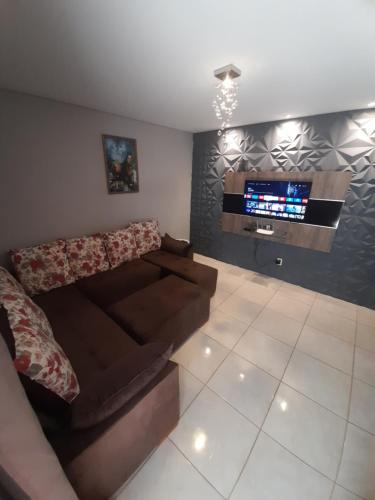 a living room with a couch and a flat screen tv at LUZ DO LUAR in Pedra Azul