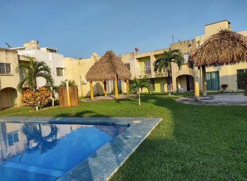 a resort with a swimming pool in front of a building at Casa del tío armando in Coatzacoalcos