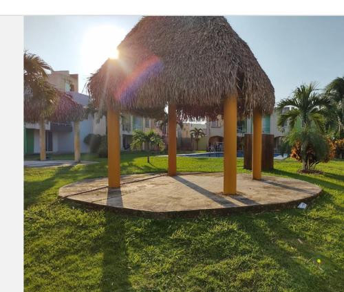 una gran cabaña de paja con un arco iris en la hierba en Casa del tío armando, en Coatzacoalcos