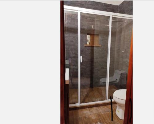 a bathroom with a toilet and a glass shower at Casa del tío armando in Coatzacoalcos