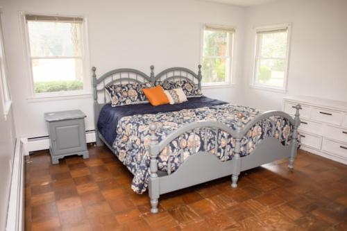 um quarto com uma cama com uma almofada laranja em Hinterland House 