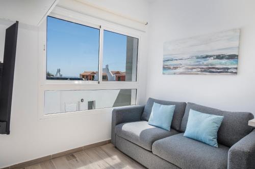 a living room with a couch and a window at Miramar in Tarajalejo