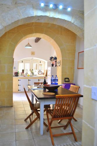 a kitchen and dining room with a table and chairs at Dar Ghax-Xemx Farmhouse in Victoria