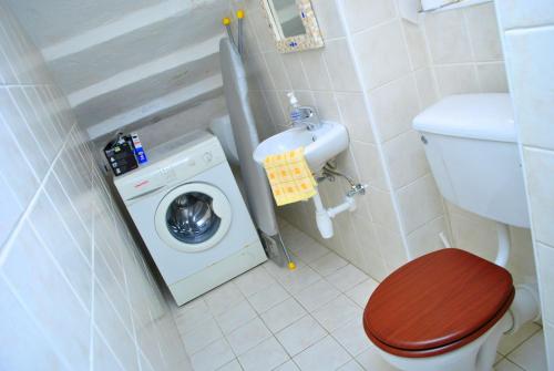 a bathroom with a toilet and a washing machine at Dar Ghax-Xemx Farmhouse in Victoria