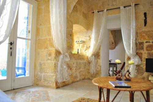 a room with a table and a stone wall at Dar Ghax-Xemx Farmhouse in Victoria