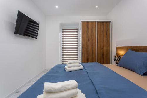 a bedroom with a blue bed with towels on it at Villa Nela Apartments in Crikvenica