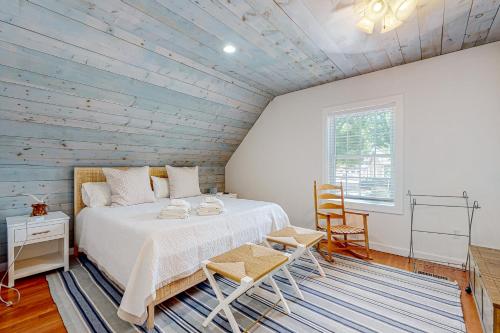 1 dormitorio con 1 cama y pared de madera en Island Time, en Vineyard Haven