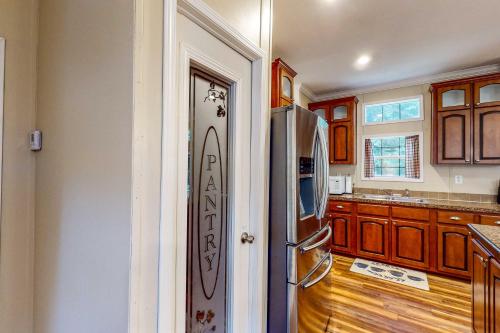 a kitchen with a refrigerator and wooden cabinets at Gallop Away in Williston