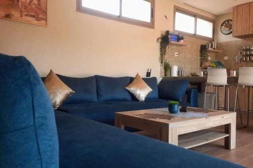 Sofá azul en la sala de estar con mesa en Lake House Boulaouane en El Jadida