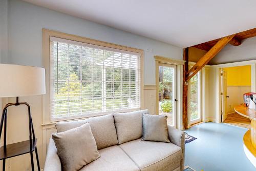 a living room with a couch and a window at Garden Hideaway in Wiscasset