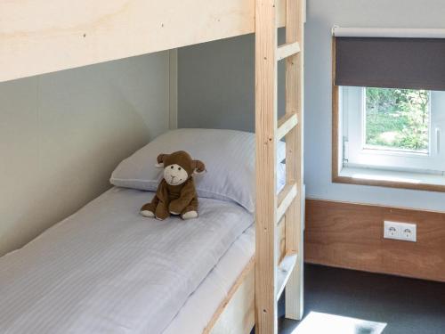 a teddy bear sitting on top of a bunk bed at Thatched Home in Overijssel in De Bult