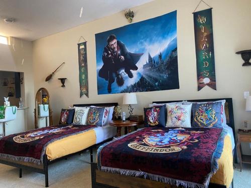 a bedroom with two beds and a poster on the wall at Mario & Harry Potter Loft Universal Studios 10min loft apartment in Los Angeles
