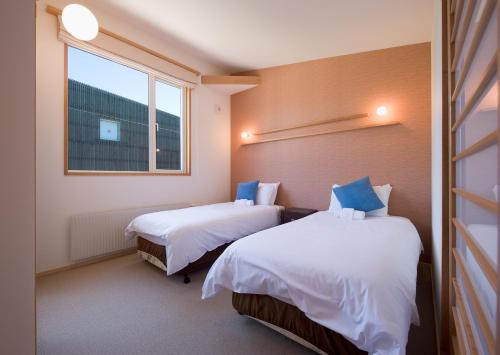 two beds in a room with a window at Shinsetsu in Kutchan