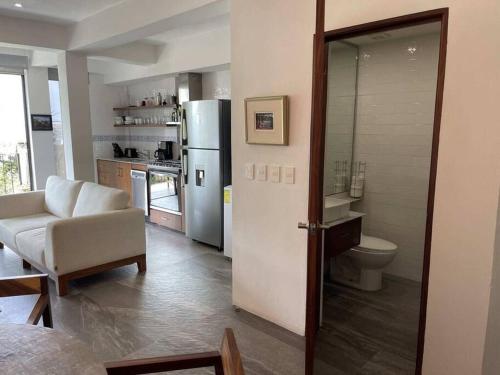 Il comprend un salon avec un réfrigérateur et une cuisine. dans l'établissement Modern city living close to EVERYTHING, à Puerto Vallarta