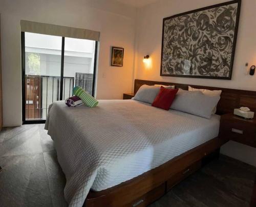 une chambre avec un grand lit et une grande fenêtre dans l'établissement Modern city living close to EVERYTHING, à Puerto Vallarta