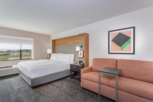 una camera d'albergo con letto e divano di Holiday Inn - Columbus, an IHG Hotel a Columbus