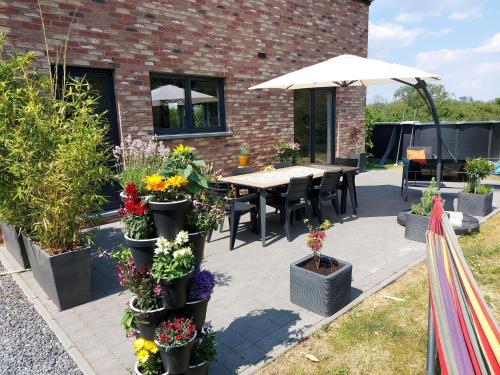 a patio with a table with flowers and an umbrella at Holiday home in Noiseux with fenced garden in Noiseux
