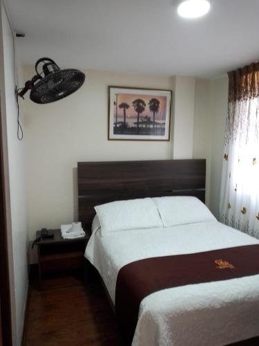 a bedroom with a large bed and a telephone at HOSTAL CORAL in Ilo