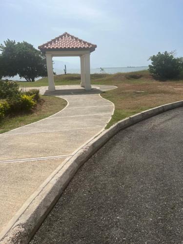 a walkway with a gazebo next to a road at Bayfront Villa & Apartment in Portmore
