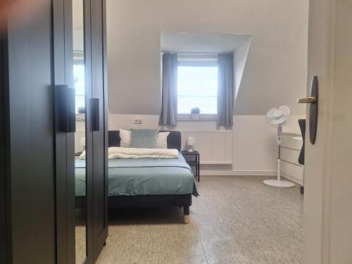 a bedroom with a bed and a window at Studio Apartment 23 - 3R2 in Essen
