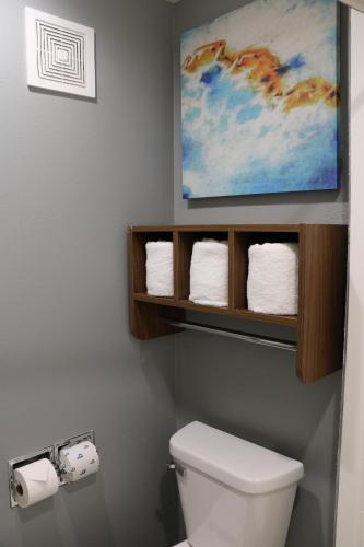 a bathroom with a toilet with a painting on the wall at La Quinta by Wyndham Chicago Gurnee in Gurnee