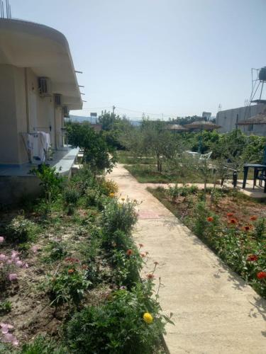 a dirt path next to a garden with flowers at Rey Garden 2 in Vlorë