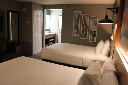 a hotel room with two beds and a bathroom at La Quinta by Wyndham Chicago Gurnee in Gurnee