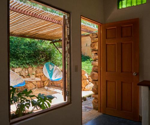 una puerta abierta a un patio con sillas y mesa en Hostal Juan Palitos, en Los Santos
