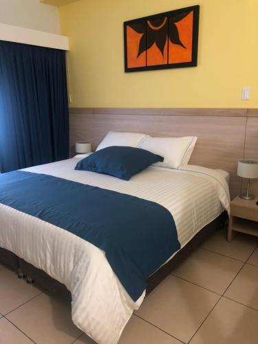 - une chambre dotée d'un grand lit avec des draps bleus et blancs dans l'établissement Hostel paradise St, à Santa Marta