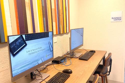 a desk with two computer monitors and a keyboard at Holiday Inn Express & Suites - Prospect Heights by IHG in Prospect Heights