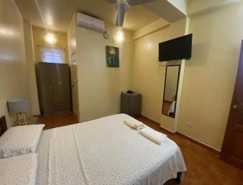 普卡爾帕的住宿－Recover，一间卧室配有两张带白色床单的床和一台平面电视