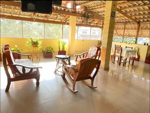 une chambre avec des chaises, une table et une télévision dans l'établissement Recover, à Pucallpa