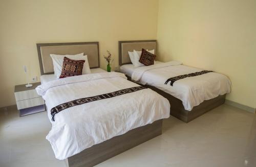 two beds sitting next to each other in a room at Ara Garden Inn, Accommodation, Yoga studio & Spa in Ruteng