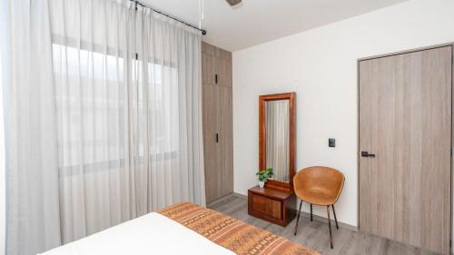 a bedroom with a bed and a chair and a window at 4BR Oasis with Pool & Gym at Nueva Escondida in San Miguel de Allende