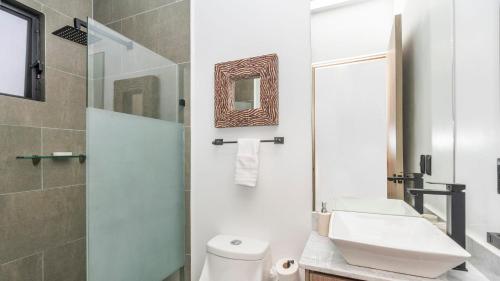 a bathroom with a white toilet and a sink at 4BR Oasis with Pool & Gym at Nueva Escondida in San Miguel de Allende